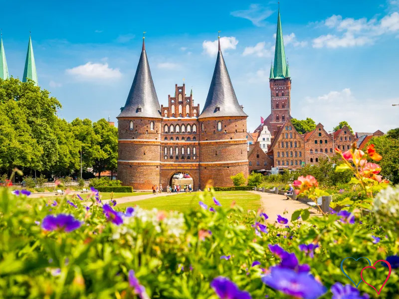 Historisches Holstentor in Schleswig-Holstein mit blühendem Park und sonniger Altstadt – stilvolle Kulisse für aufregende Sexdates.