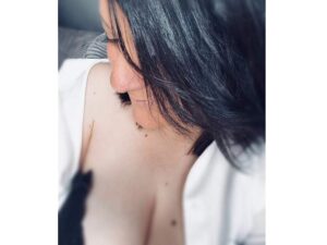 Viki mit schwarzem Haar und braunen Augen in natürlicher Pose