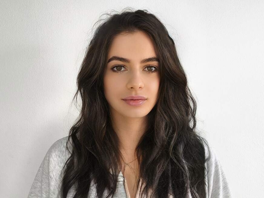 Carli mit brünettem Haar und braunen Augen in natürlicher Pose