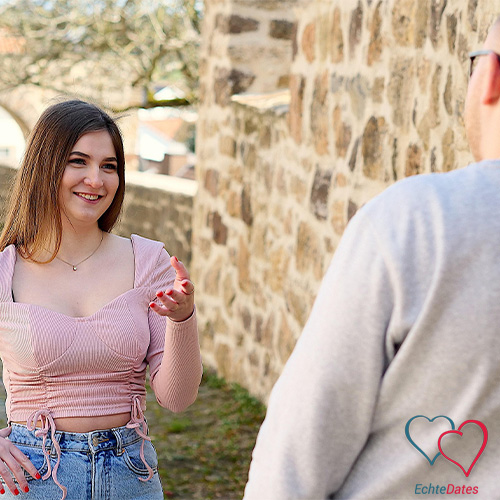 Frau beim ersten Date lächelt und spricht mit einem Mann – Frauen online kennenlernen auf EchteDates